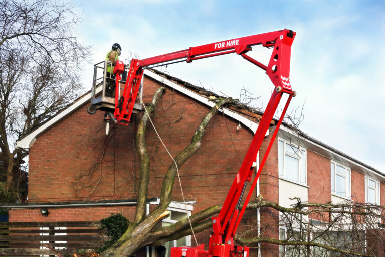 Tree Surgeon Working Up Cherry Picker Repairing Storm Damaged Ro