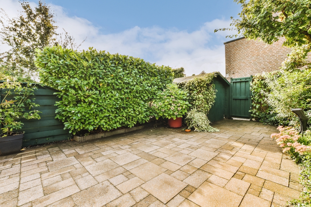 Neat,paved,patio,with,sitting,area,and,small,garden,near